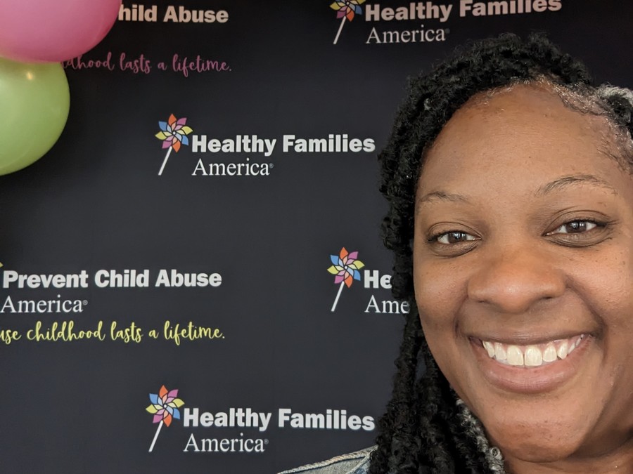 Gigi in front of freshly rebranded PCAA and Healthy Families America signage